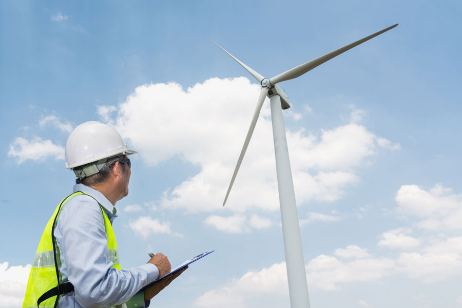 Foto zeigt einen H&M Ingenieurbüro Gutachter vor einer Windkraftanlage | Baubegleitung